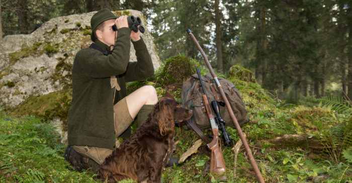 Jäger mit Fernglas, Hund, Jagdstock und Büchse